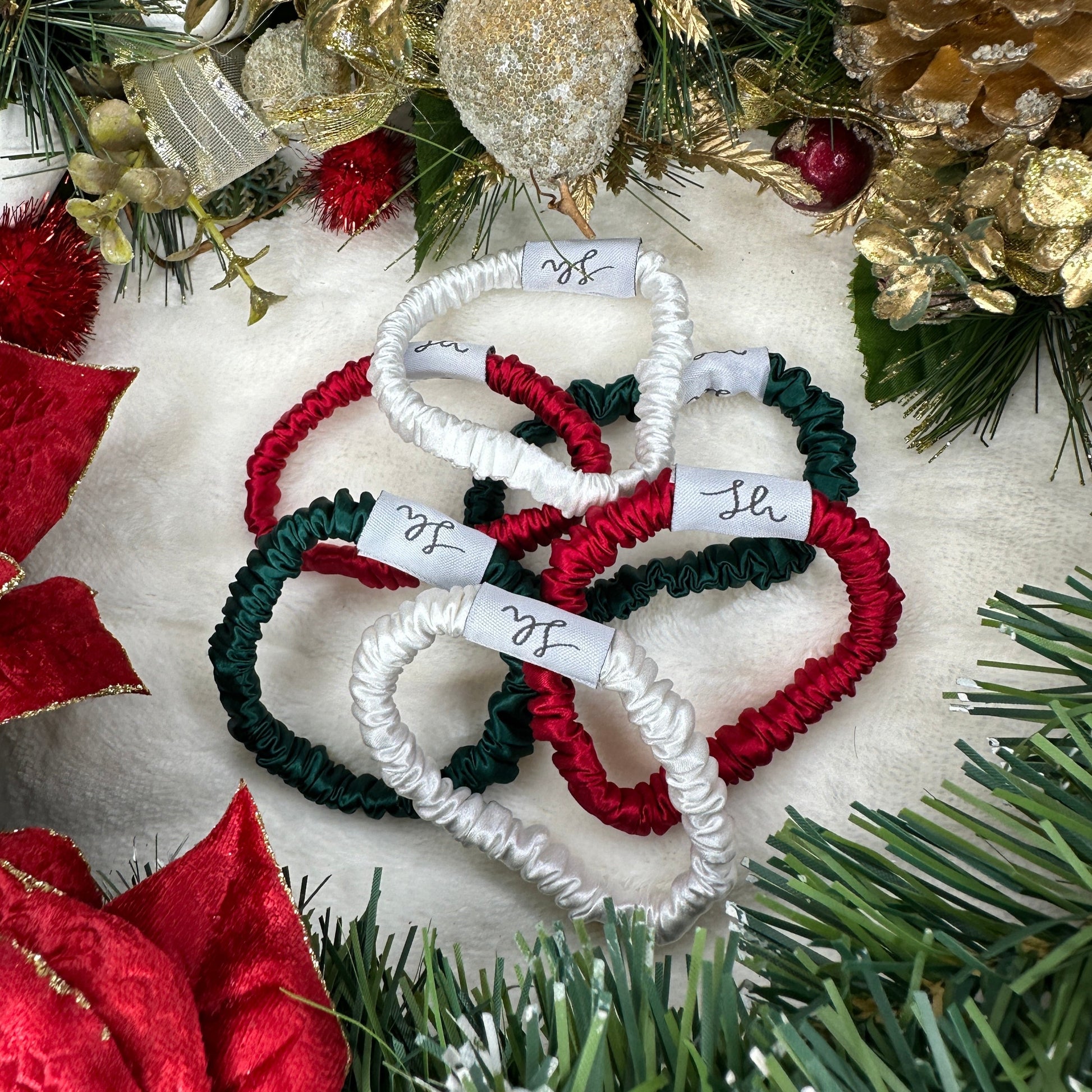 Sioda Hair Silky Range, The Christmas Collection 100% Mulberry Silk scrunchies in white, green and red set against a white powder effect surrounded by a christmas wreath, size small